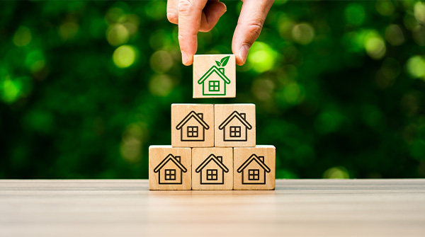 piramide di cubi di legno con casetta verde disegnata sopra