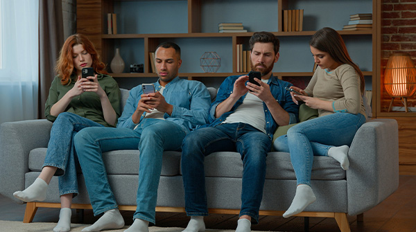 persone sul divano che usano smartphone