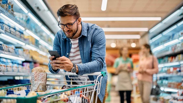 ragazzo al supermercato al telefono