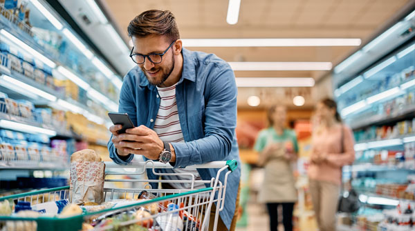ragazzo al supermercato al telefono