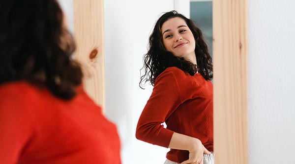 donna si guarda allo specchio sorride